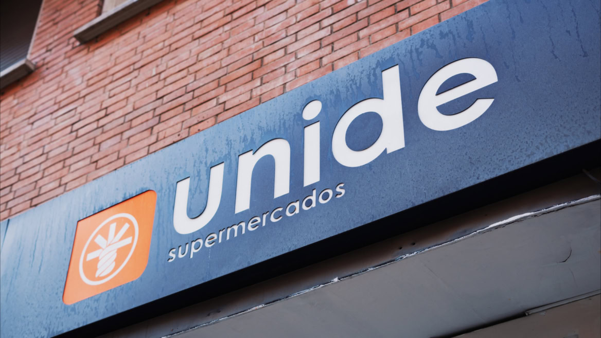 cartel del supermercado unide en fachada de ladrillo