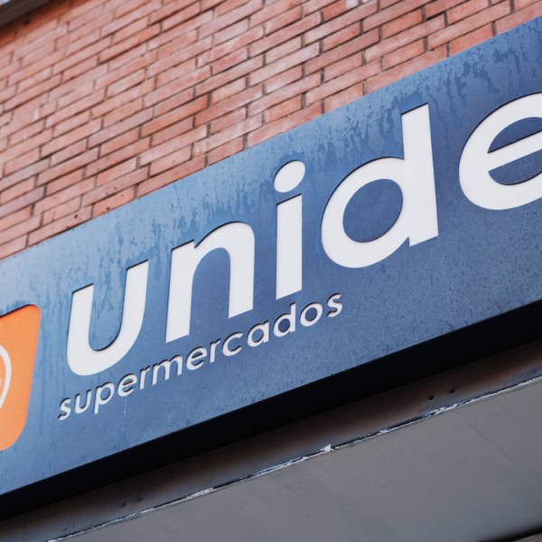 cartel del supermercado unide en fachada de ladrillo