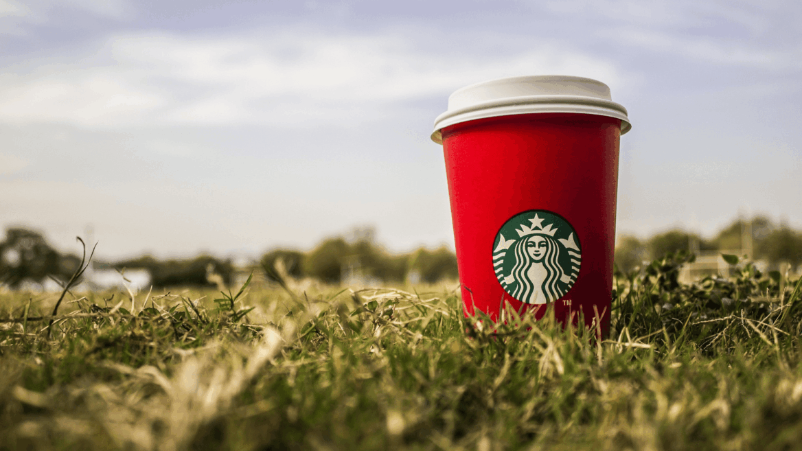 vaso con logo de starbucks entre la hierba