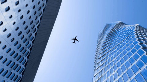 avión vuela entre edificios