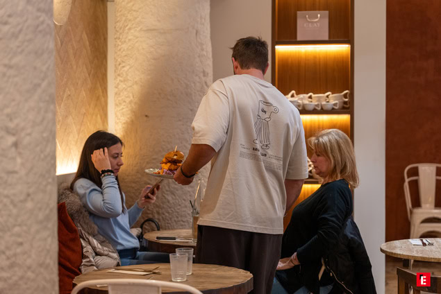 café chaleureux: serveur apporte dessert à deux clientes