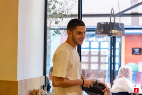client au café avec porte monnaie sous lumière naturelle