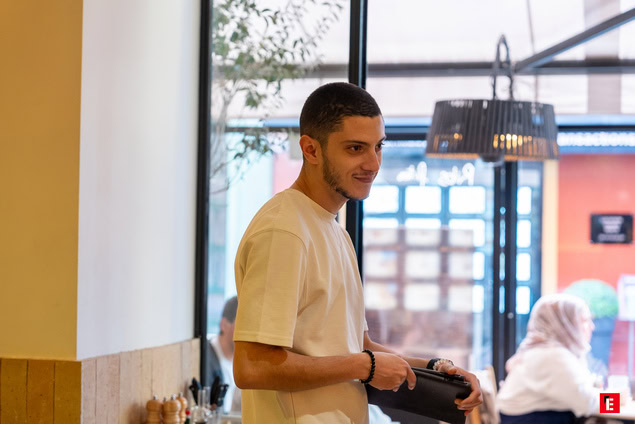 client au café avec porte monnaie sous lumière naturelle