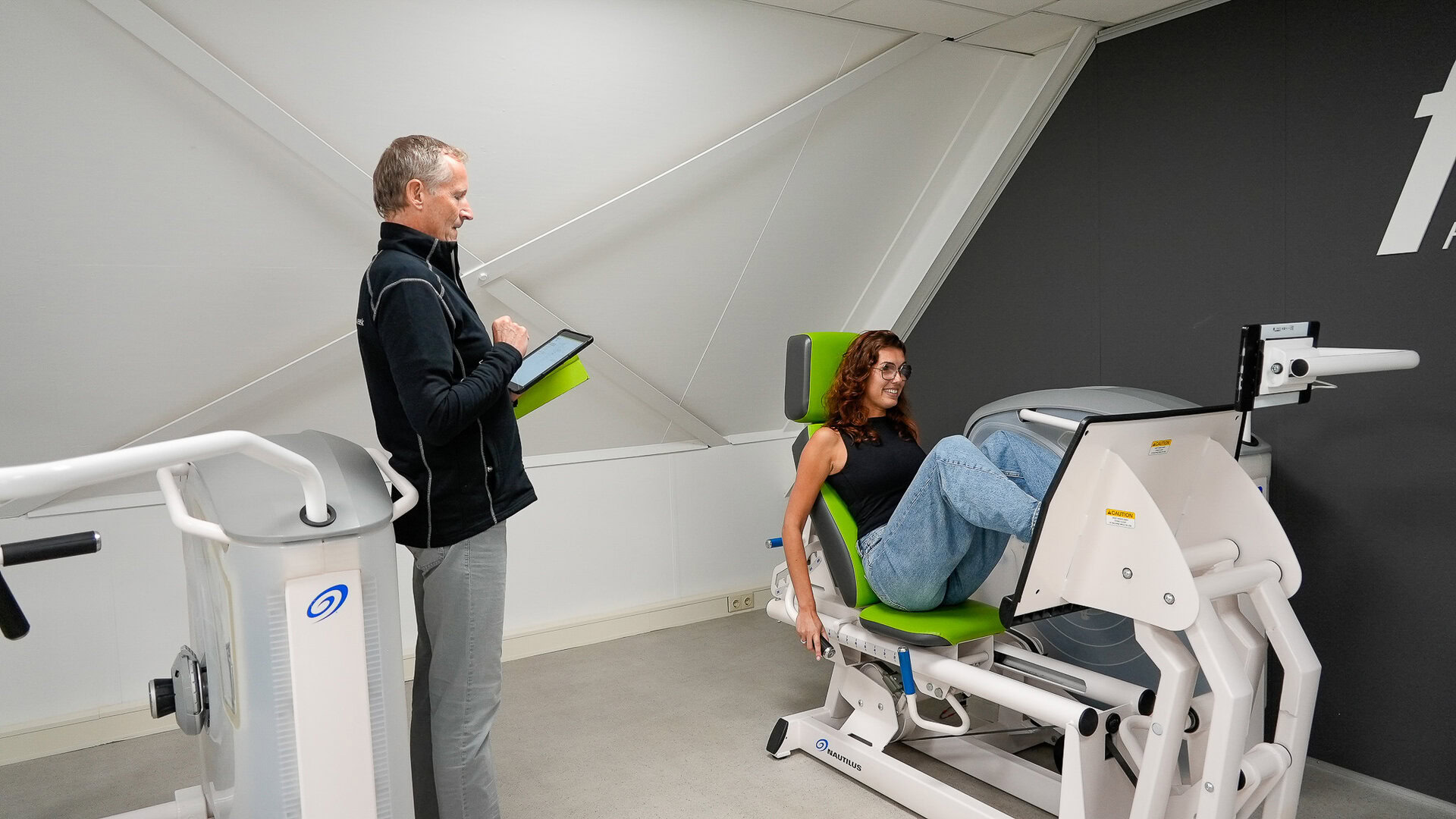 eine frau bei einer elektrostimulationssitzung mit ihrem trainer