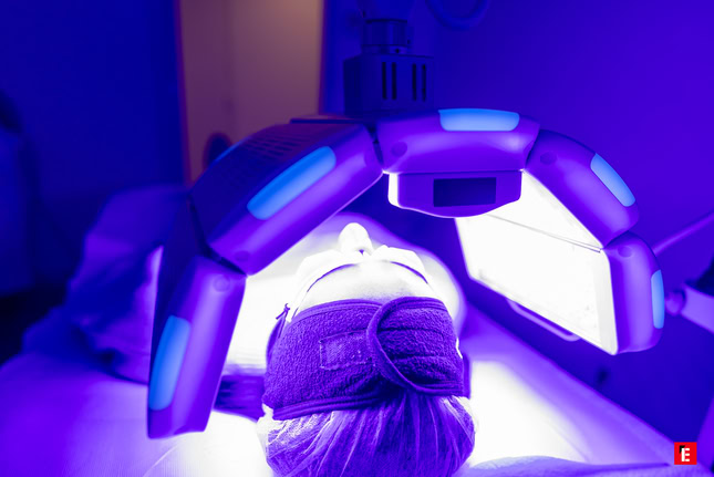 cliente en soin avec un appareil sur sa tête à lumières violettes