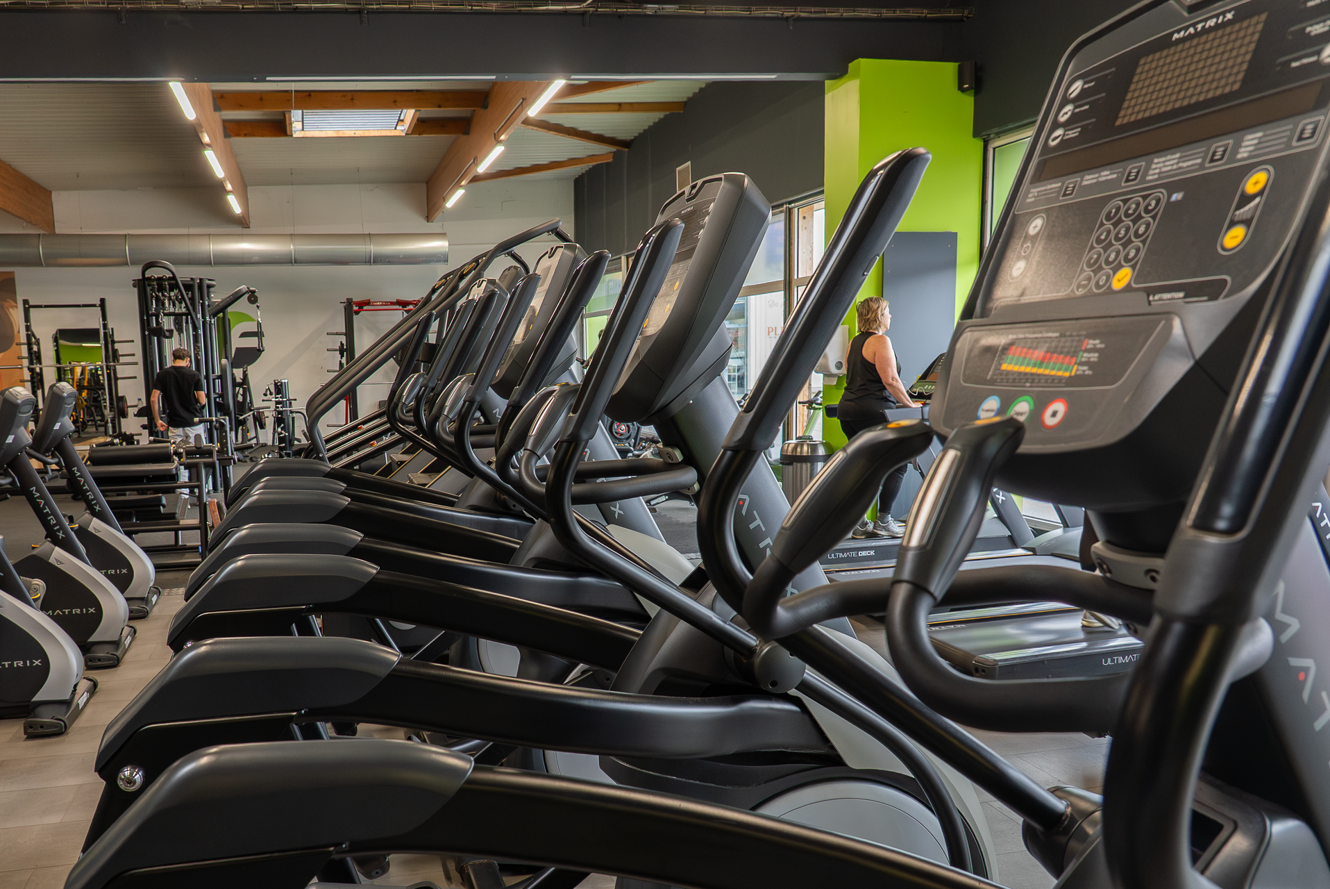 salle de sport lumineuse avec elliptiques matrix