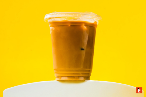 iced coffee in plastic cup on yellow background