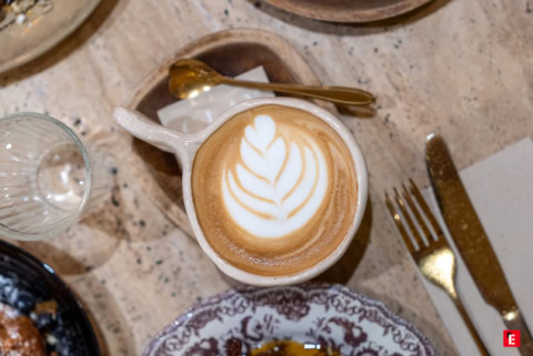 tasse de latte art rosetta et cuillère dorée