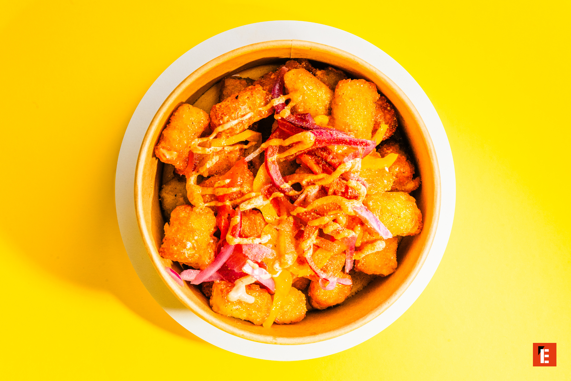 crispy tater tots with pickled onions and drizzled sauce