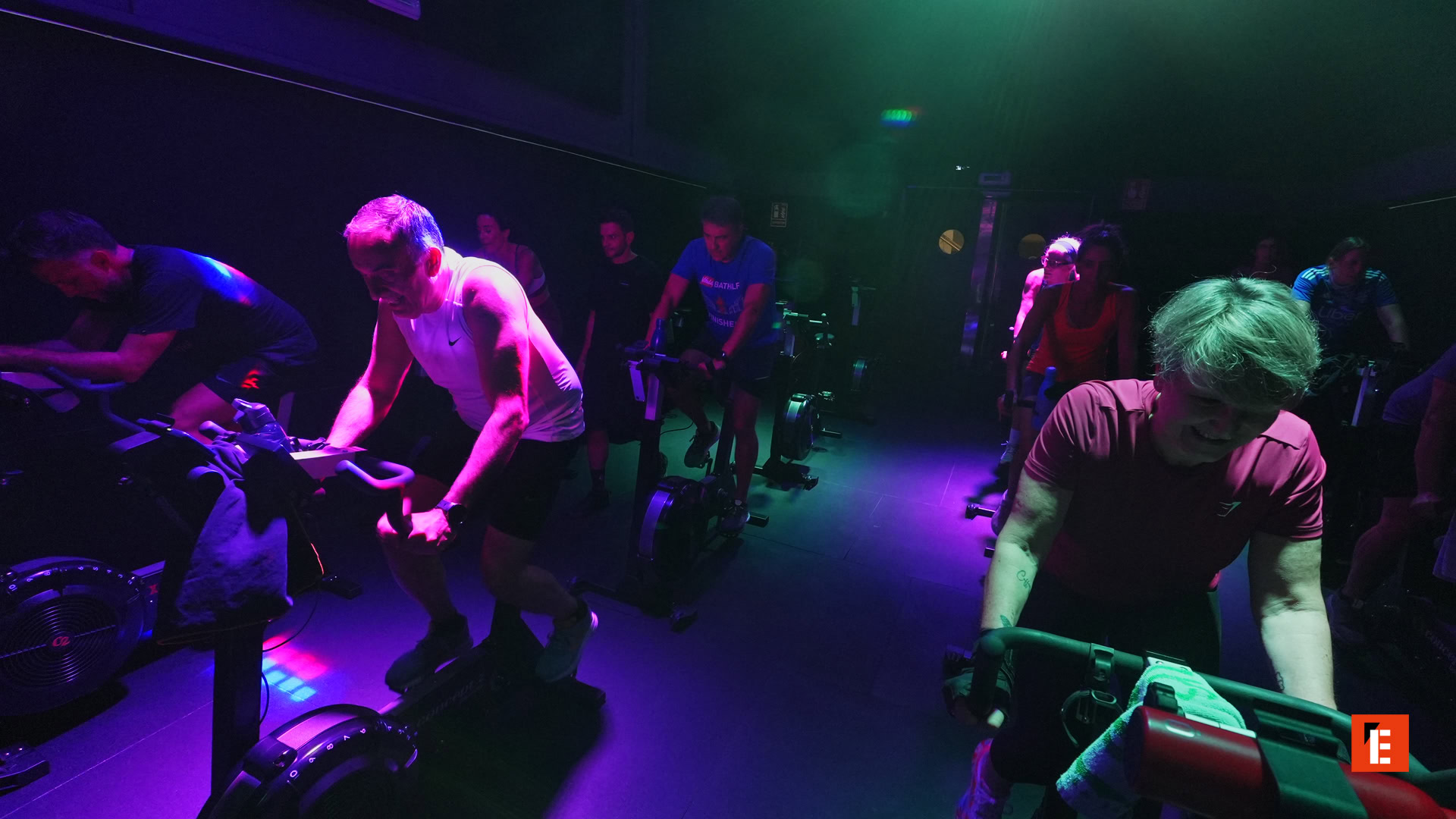 clase de spinning bajo luces neón azules