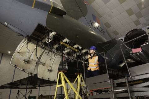 workers inspect blue aerial lift during safety check