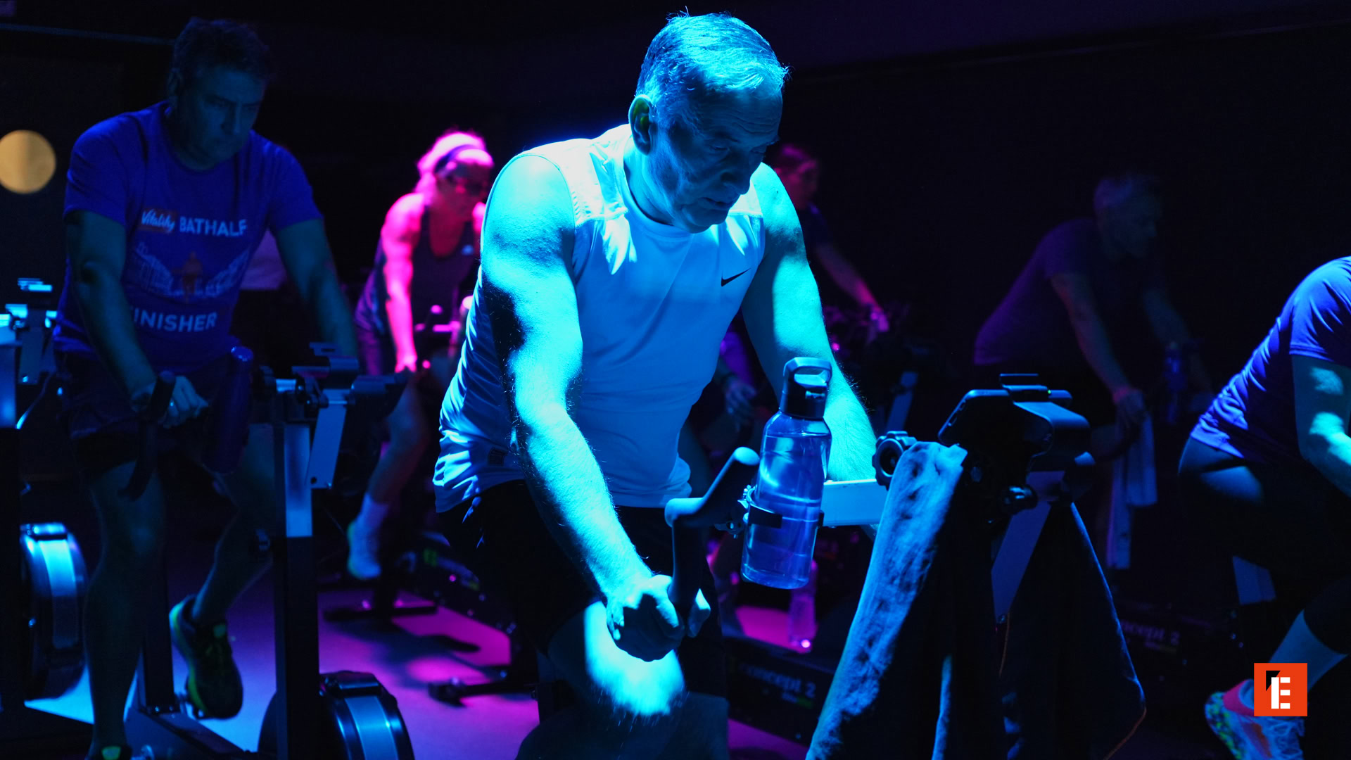 clase de spinning bajo luces neón