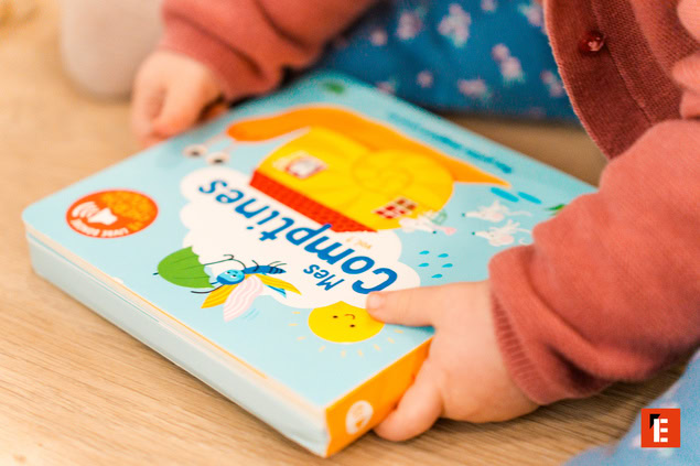 bébé tenant livre cartonné de comptines musicales