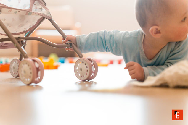 bébé touche la roue dune poussette jouet