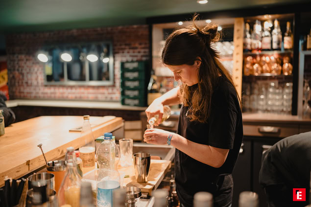 mixologue prépare un cocktail au comptoir chaleureux