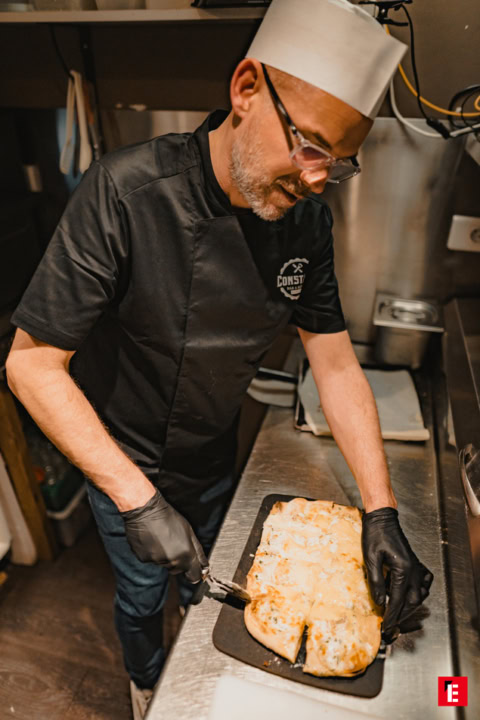 chef découpe fromage fondant sorti du four