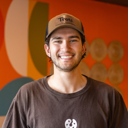 portrait dhomme souriant en casquette devant mur coloré