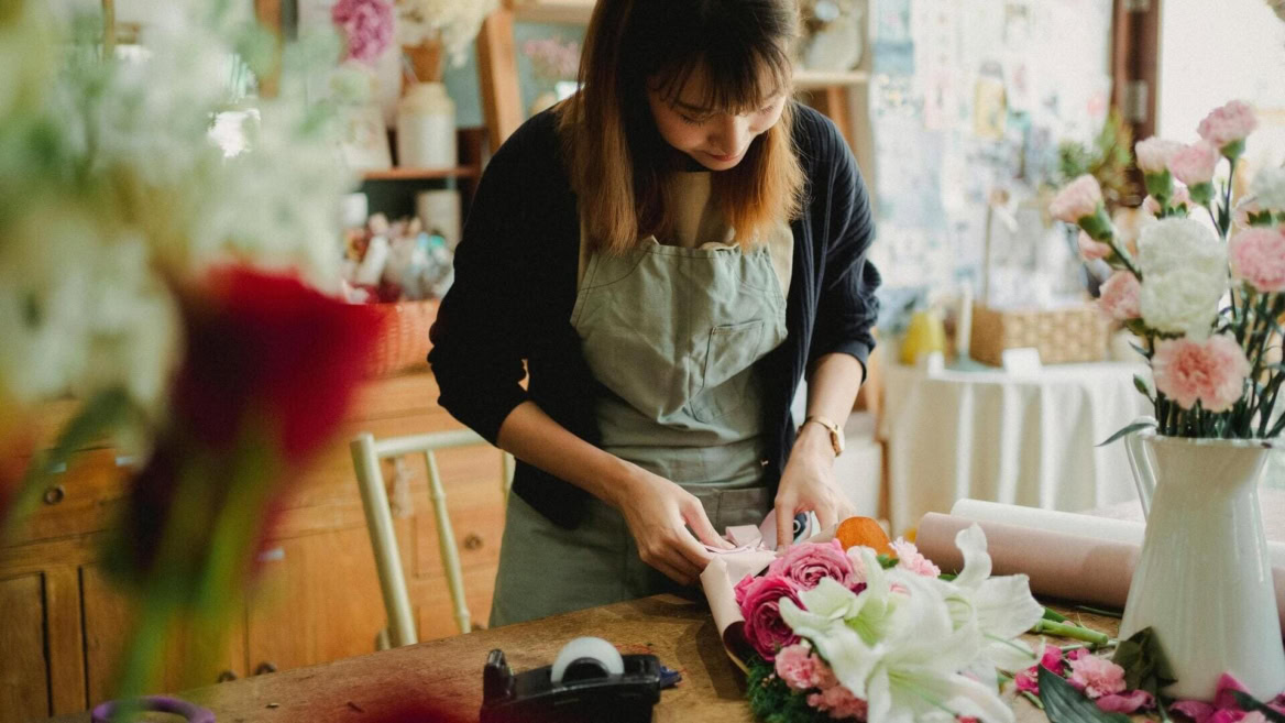 fleuriste enveloppe un bouquet