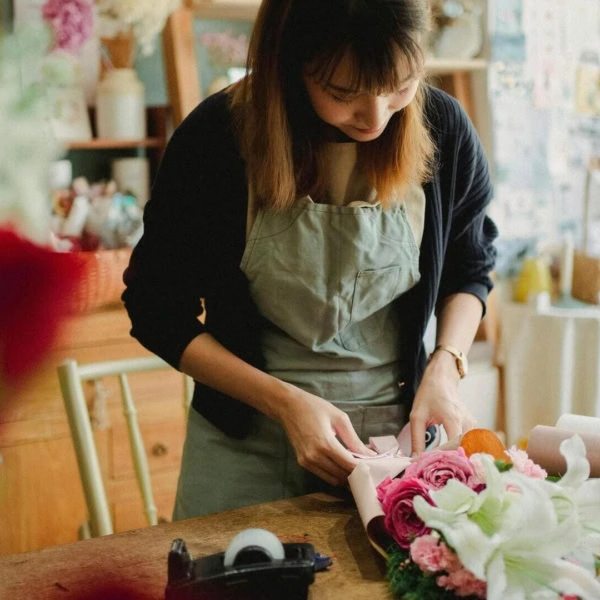 fleuriste enveloppe un bouquet