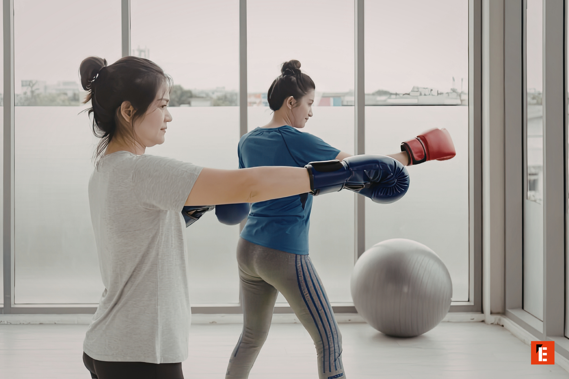 female boxer training on heavy bag in gym