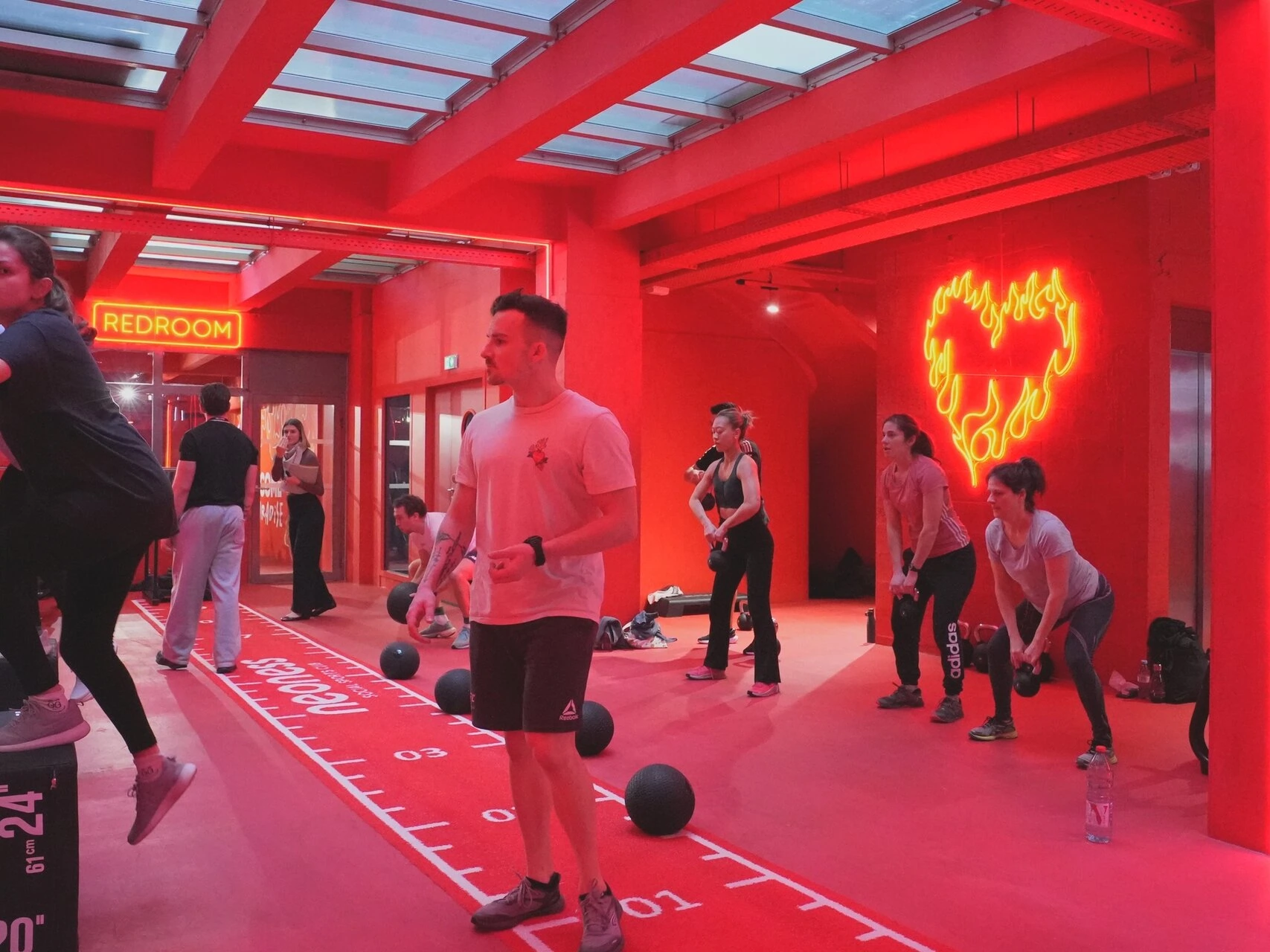 Un coach de sport dans une salle rouge de sport