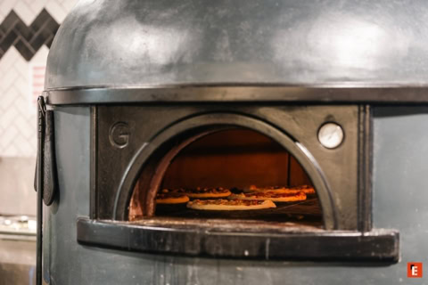 Pizza with pepperoni and two glasses of wine.