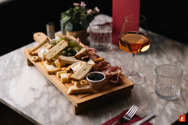 Plate of pasta with sauce and glass of wine.