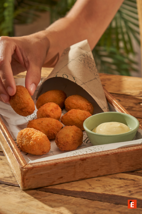croquetas crujientes con salsa en bandeja rústica