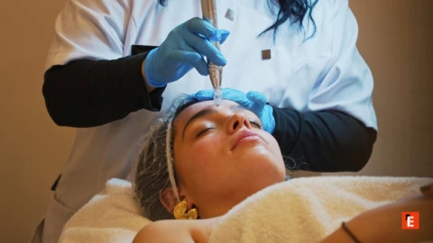 Manicura profesional con esmalte rosa y herramientas.