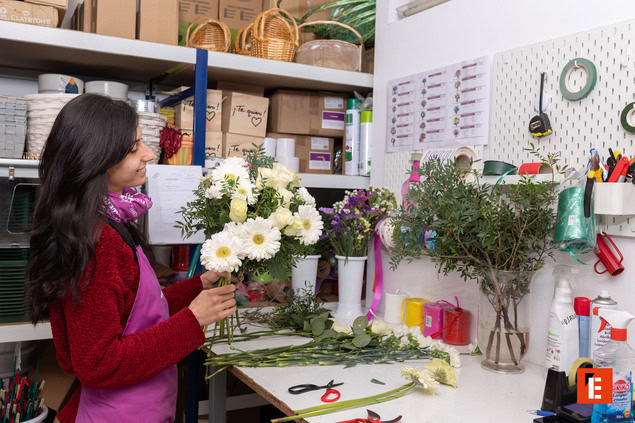 Hombre sonriente sosteniendo flores en taller.