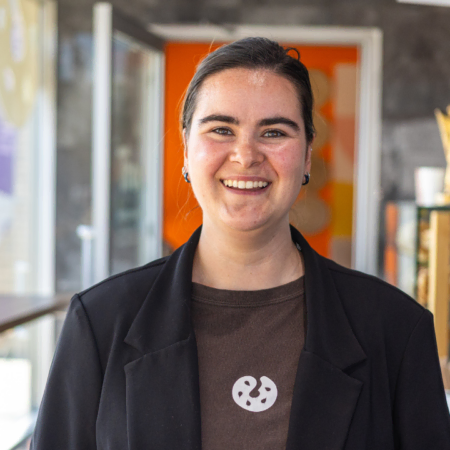 portrait de femme souriante en blazer près dune fenêtre