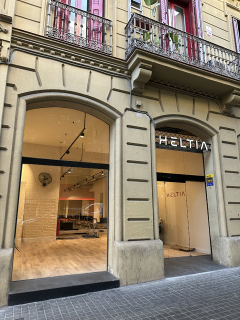 fachada histórica con escaparate moderno y balcones de hierro