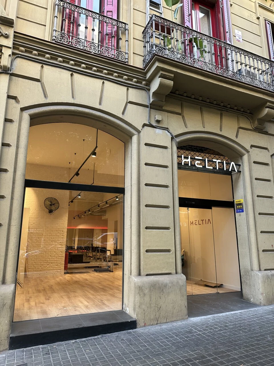 fachada histórica con escaparate moderno y balcones de hierro