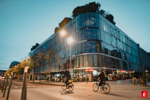 immeuble moderne en verre avec terrasse et café