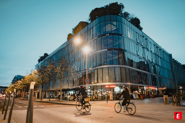immeuble moderne en verre avec terrasse et café