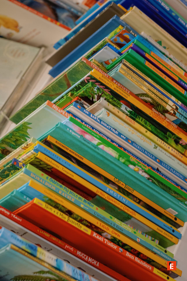 scaffale colorato di libri illustrati per bambini
