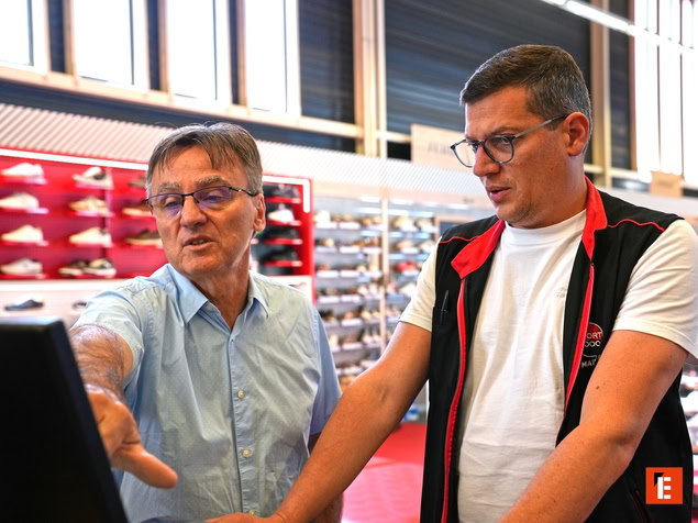 conseil client devant Écran en magasin de chaussures