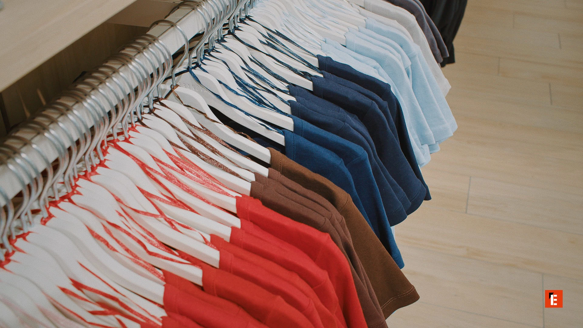 magliette colorate appese su grucce in negozio