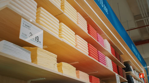 magliette piegate su scaffali in legno per colori e prezzi