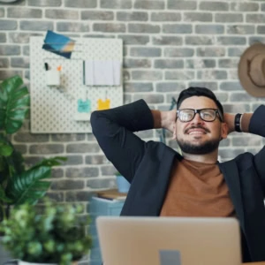 man with glasses working on his laptop smiling
