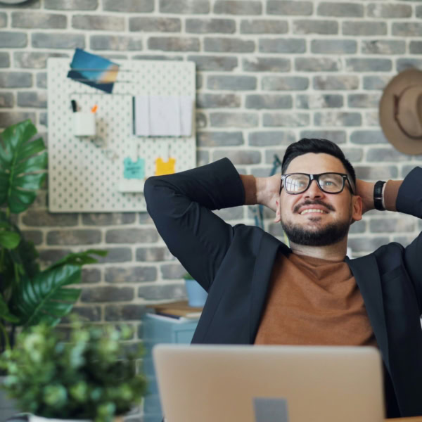 man with glasses working on his laptop smiling