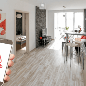 mano con móvil y app airbnb en apartamento