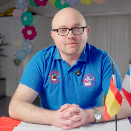seated presenter in blue polo with flags