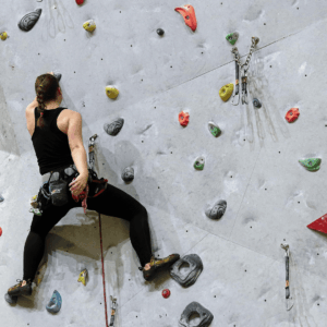 mujer escalando un rocódromo