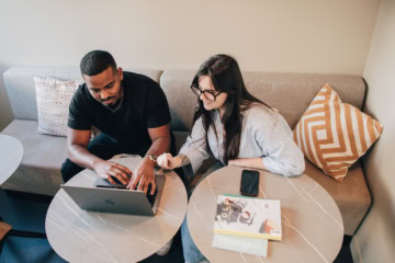Une femme et un homme à table avec leurs ordinateurs