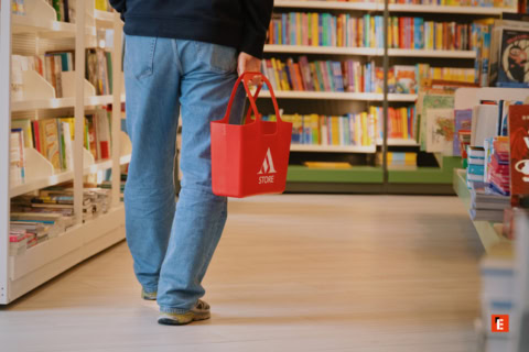 persona con cestino rosso in libreria