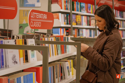 donna legge tra classici e tascabili in libreria