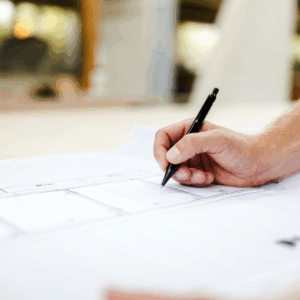 White hand writing something on a sheet of paper