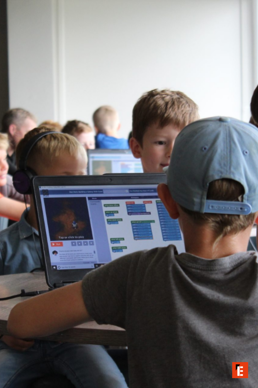 kids coding workshop around a laptop