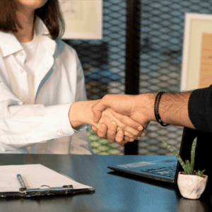 Close-up of two people shaking hands, we cannot see their faces.